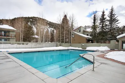 a swimming pool in a yard with snow at 1196 Flying Dutchman condo in Keystone
