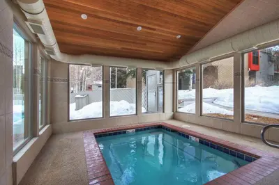 a swimming pool in a house with windows at 1196 Flying Dutchman condo in Keystone