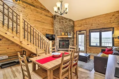 a dining room and living room with a table and chairs at Cozy Granby Mountain Condo with Resort Amenities! in Granby
