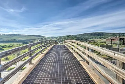 a walkway on a bridge with mountains in the background at Cozy Granby Mountain Condo with Resort Amenities! in Granby