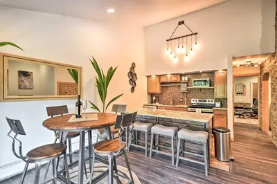 a kitchen and dining room with a table and stools at Estes Park Condo about 1 Mi to RMNP! in Estes Park
