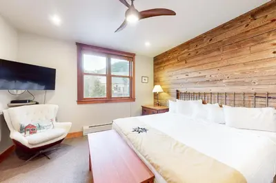a bedroom with a large bed and a chair at Red Hawk Townhome 2350 in Keystone