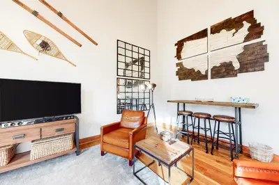 a living room with a tv and a chair and a table at Red Hawk Townhome 2350 in Keystone