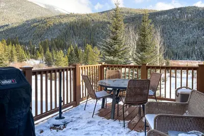 a deck with a table and chairs in the snow at Red Hawk Townhome 2350 in Keystone