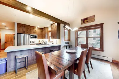 a kitchen and dining room with a wooden table and chairs at Red Hawk Townhome 2350 in Keystone