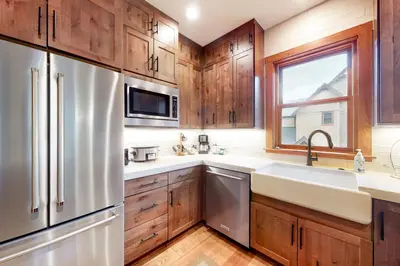 a kitchen with wooden cabinets and a stainless steel refrigerator at Red Hawk Townhome 2350 in Keystone