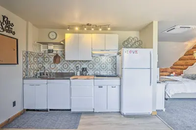 a kitchen with white cabinets and a white refrigerator at Fraser Couples Hideaway with Indian Peaks View in Fraser
