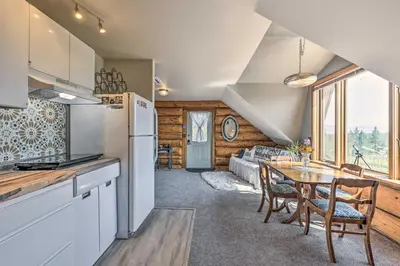 a kitchen and dining room with a table and a refrigerator at Fraser Couples Hideaway with Indian Peaks View in Fraser