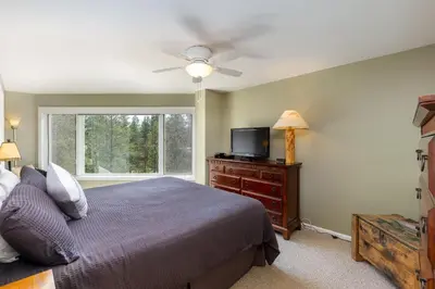 a bedroom with a bed and a flat screen tv at 2105 The Pines condo in Keystone