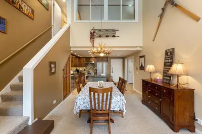 a dining room and kitchen with a table and a staircase at 2105 The Pines condo in Keystone