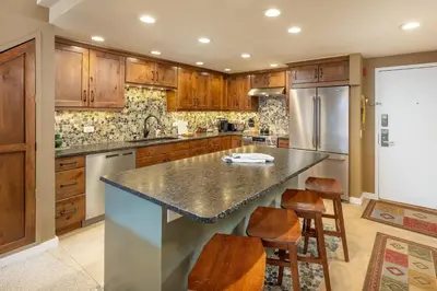 a kitchen with wooden cabinets and a large island at 2105 The Pines condo in Keystone