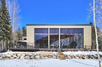 a house with large glass windows in the snow at 2105 The Pines condo in Keystone