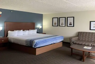 a hotel room with a bed and a chair at AmericInn by Wyndham Windsor Ft. Collins in Fort Collins