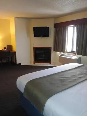 a hotel room with a bed and a fireplace at AmericInn by Wyndham Windsor Ft. Collins in Fort Collins
