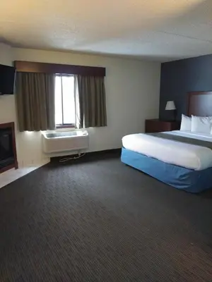 a hotel room with a bed and a window at AmericInn by Wyndham Windsor Ft. Collins in Fort Collins
