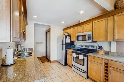 a kitchen with wooden cabinets and white appliances at Mountain Dreams Condo in Fraser