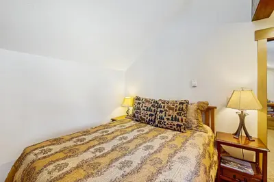 a bedroom with a bed and a lamp on a night stand at Mountain Dreams Condo in Fraser