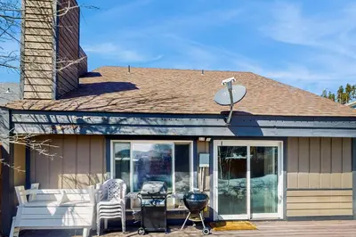 a house with a grill and chairs on a deck at Mountain Dreams Condo in Fraser