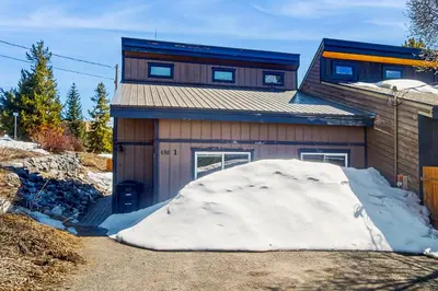 a house with a large snow pile in front of it at Mountain Dreams Condo in Fraser