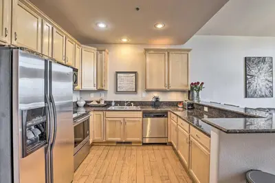 a kitchen with wooden cabinets and a stainless steel refrigerator at 7 Mi to Slopes Main Street Condo in Dillon in Dillon