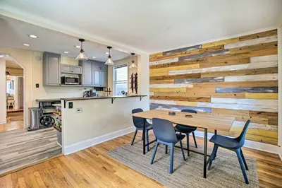 a kitchen and dining room with a wooden wall at Modern House with Yard Less Than 7 Mi to Downtown Denver! in Denver