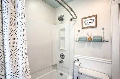 a white bathroom with a shower and a toilet at Modern House with Yard Less Than 7 Mi to Downtown Denver! in Denver
