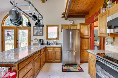 a kitchen with wooden cabinets and a stainless steel refrigerator at Silver Plume Mountain Haven with Views and Deck! in Silver Plume