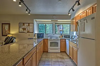 a kitchen with wooden cabinets and a white refrigerator at Less Than 2 Mi to Frisco Adventure Park Cozy Townhome! in Frisco