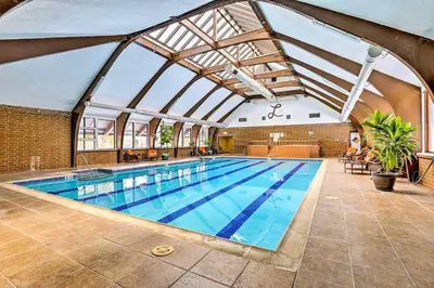 a large swimming pool with a glass ceiling at Less Than 2 Mi to Frisco Adventure Park Cozy Townhome! in Frisco
