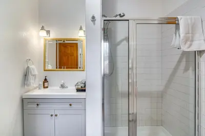 a white bathroom with a shower and a sink at Chicago Creek B and B 1 Mi to Mt Blue Sky! in Idaho Springs