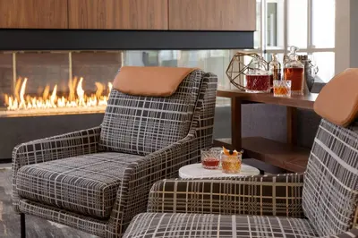 a living room with two chairs and a fireplace at The Slate Hotel Denver Downtown, Tapestry by Hilton in Denver