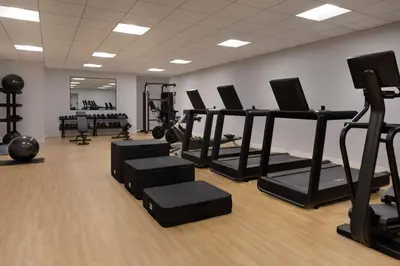 a gym with treadmills and ellipticals in a room at The Slate Hotel Denver Downtown, Tapestry by Hilton in Denver