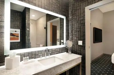 a bathroom with a sink and a mirror at The Slate Hotel Denver Downtown, Tapestry by Hilton in Denver