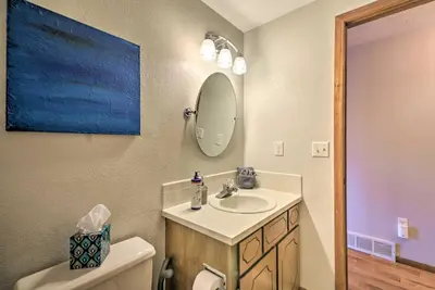 a bathroom with a sink and a mirror and a toilet at Loveland Getaway with Fire Pit and Ping Pong Table! in Loveland