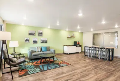 a living room with a couch and a table and chairs at WoodSpring Suites Thornton-North Denver in Thornton