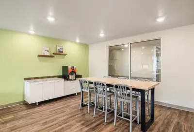 a kitchen with a table and chairs in a room at WoodSpring Suites Thornton-North Denver in Thornton