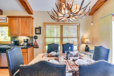 a dining room table with chairs and a chandelier at 1 Mi to Grand Lake Family-Friendly Gem with Hot Tub in Grand Lake