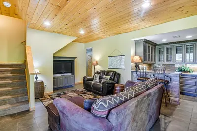 a living room with two couches and a kitchen at 1 Mi to Grand Lake Family-Friendly Gem with Hot Tub in Grand Lake