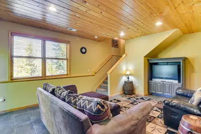 a living room with couches and a flat screen tv at 1 Mi to Grand Lake Family-Friendly Gem with Hot Tub in Grand Lake