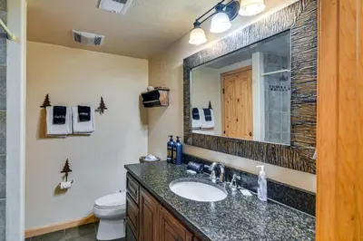 a bathroom with a sink and a toilet and a mirror at 1 Mi to Grand Lake Family-Friendly Gem with Hot Tub in Grand Lake