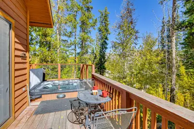 a wooden deck with a table and chairs on it at 1 Mi to Grand Lake Family-Friendly Gem with Hot Tub in Grand Lake