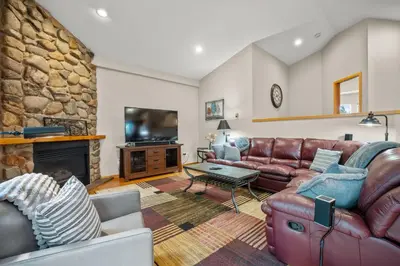 a living room with a leather couch and a fireplace at Cutty Sark Grand Combo 6BR 4,5BA townhouse in Silverthorne