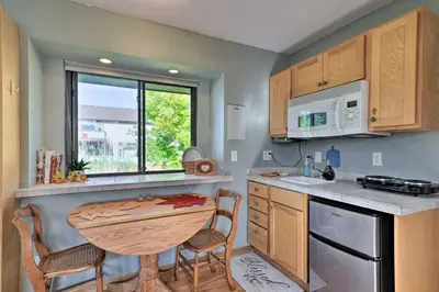 a kitchen with a wooden table and a table and chairs at Loveland Guest House with Balcony by Boyd Lake in Loveland