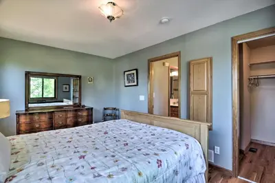 a bedroom with a large bed and a television at Loveland Guest House with Balcony by Boyd Lake in Loveland