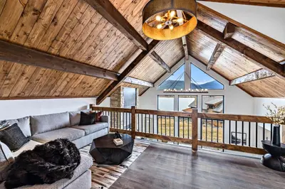a living room with a couch and a vaulted ceiling at Slice of Heaven just steps from Lake Estes! Indoor/Outdoor Fireplace and Jacuzzi in Estes Park