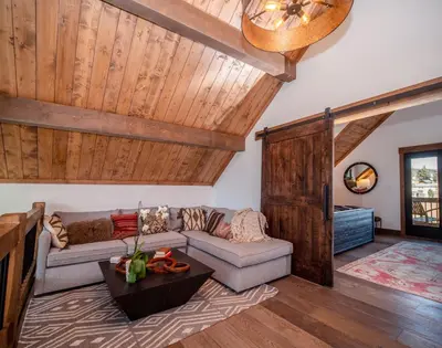 a living room with a couch and a table at Slice of Heaven just steps from Lake Estes! Indoor/Outdoor Fireplace and Jacuzzi in Estes Park