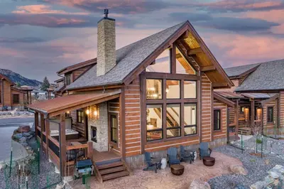 a log cabin with glass windows and a roof at Gorgeous Views! Two large Patios, Jacuzzi, Indoor/Outdoor Fireplace in Estes Park
