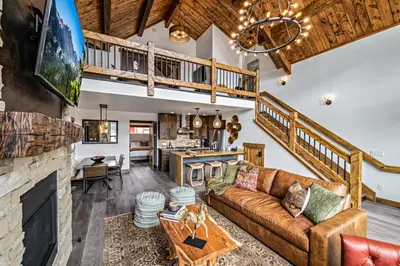a living room with a couch and a fireplace at Gorgeous Views! Two large Patios, Jacuzzi, Indoor/Outdoor Fireplace in Estes Park