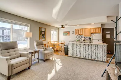 a living room with two chairs and a kitchen at 7 Mi to Ski Resort Dillon Condo with Mtn Views in Dillon