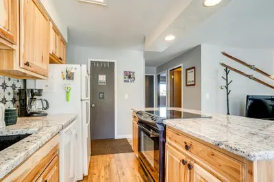 a kitchen with wooden cabinets and a counter top at 7 Mi to Ski Resort Dillon Condo with Mtn Views in Dillon